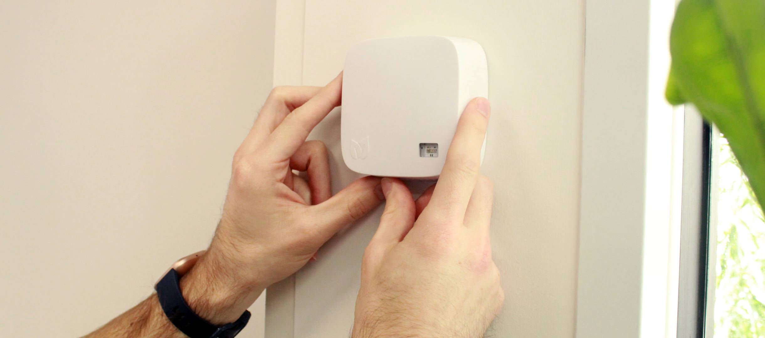 An AirSuite Sense device being mounted to the wall